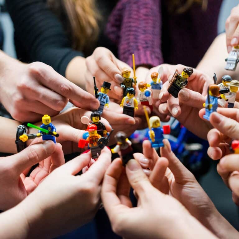 Social selling : de nombreuses mains jouent avec des Lego