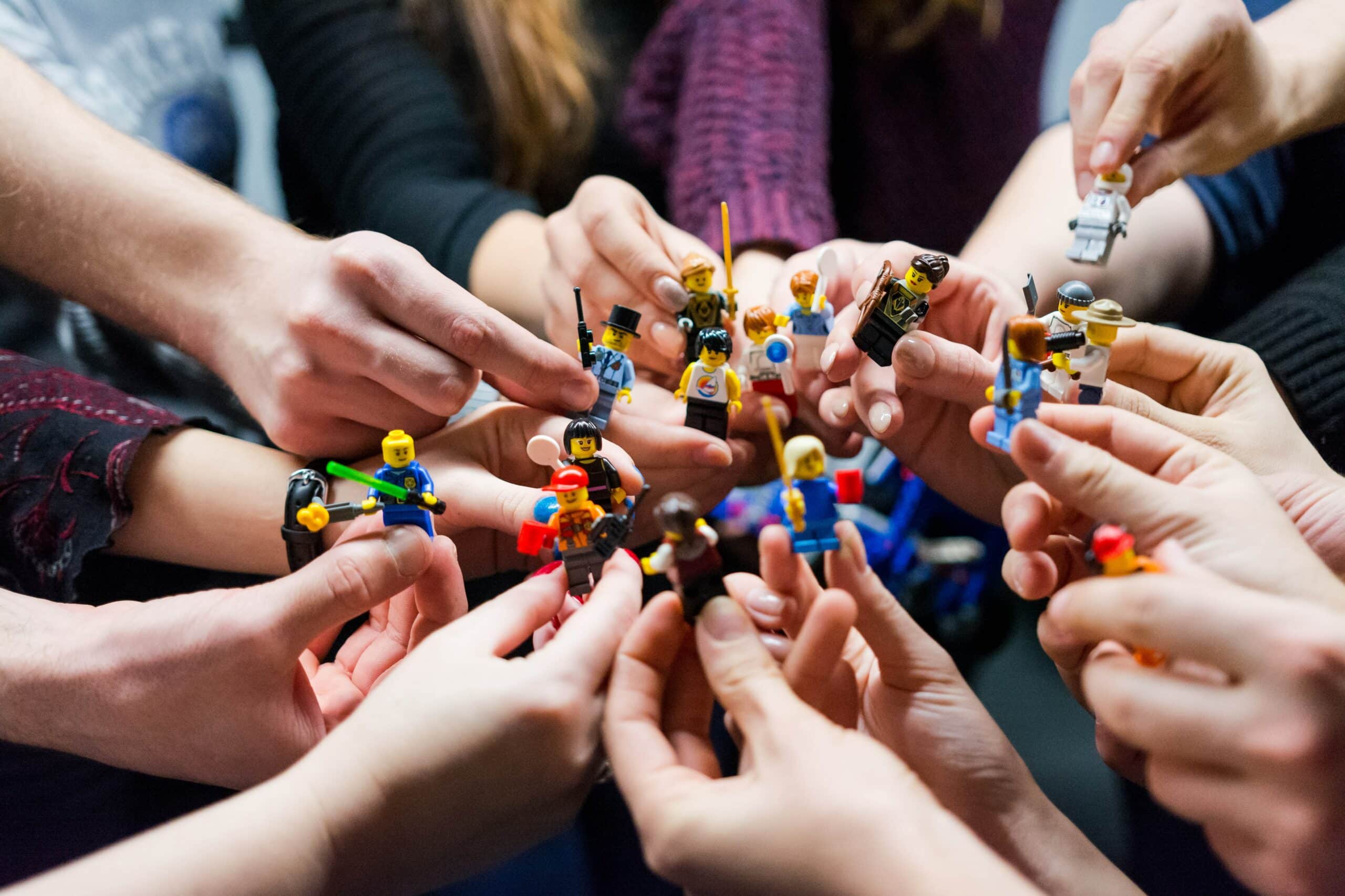 Social selling : de nombreuses mains jouent avec des Lego