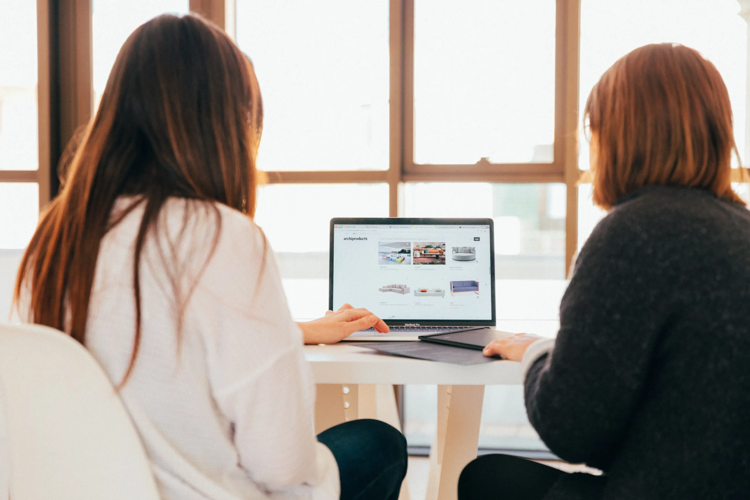 Deux femmes recherche sur un ordinateur la bonne plateforme de Commerce électronique.