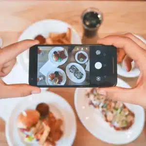 Influenceur prend une photo de nourriture lors d'une campagne de marketing d'influence efficace.