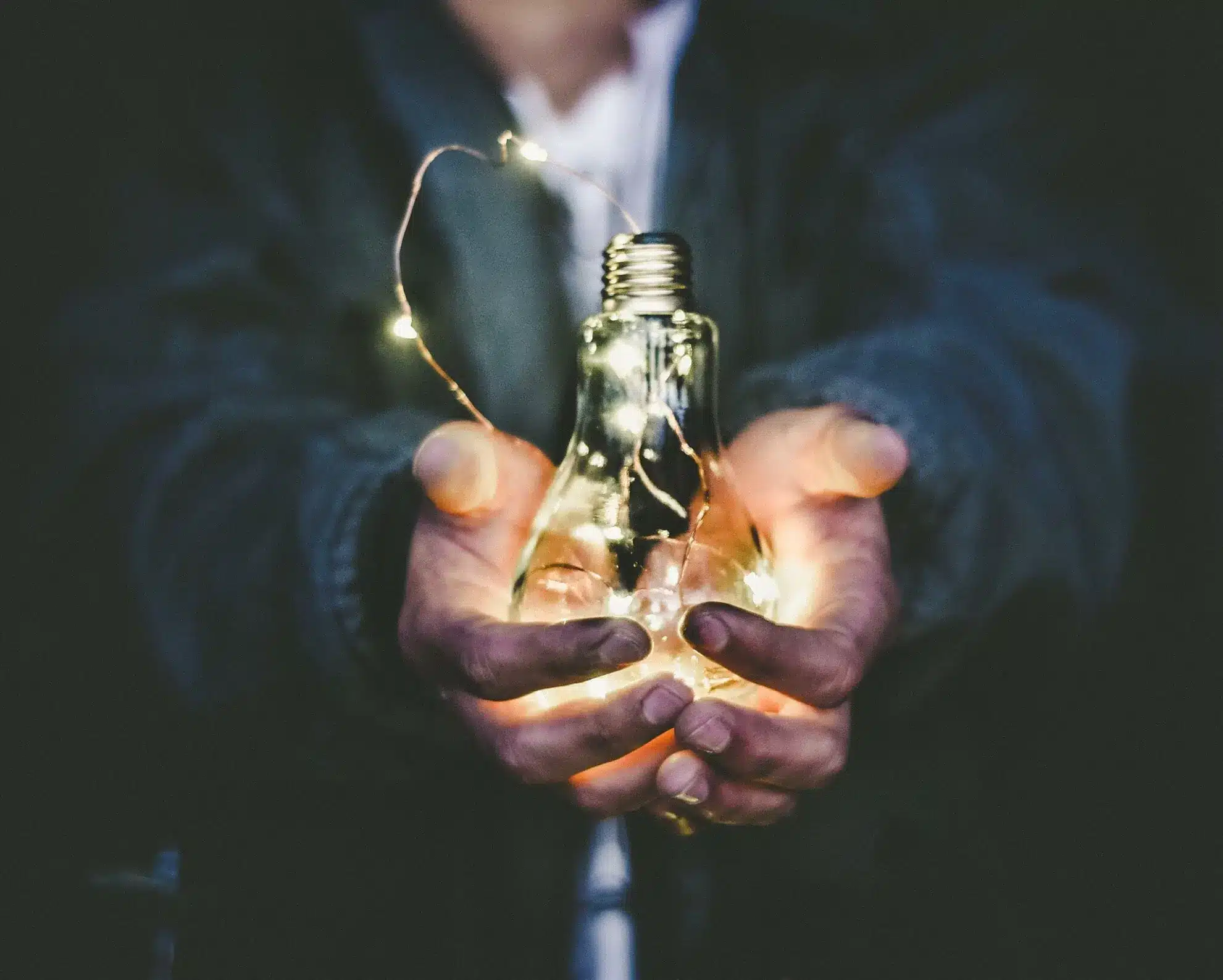 Homme tient une ampoule éclairant le choix entre Marketing produits et solutions