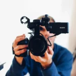 homme tenant une caméra, crucial dans sa stratégie marketing vidéo